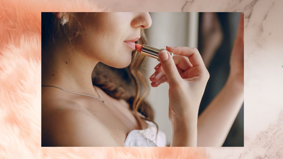 Woman putting lipstick on