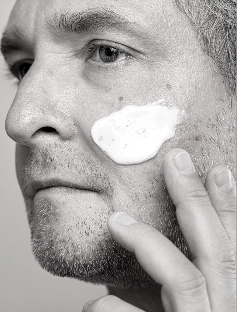 Mature man applying moisturiser