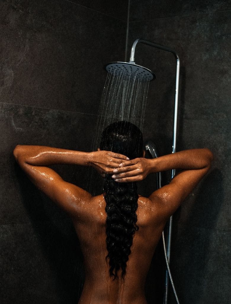 Tan woman showering 