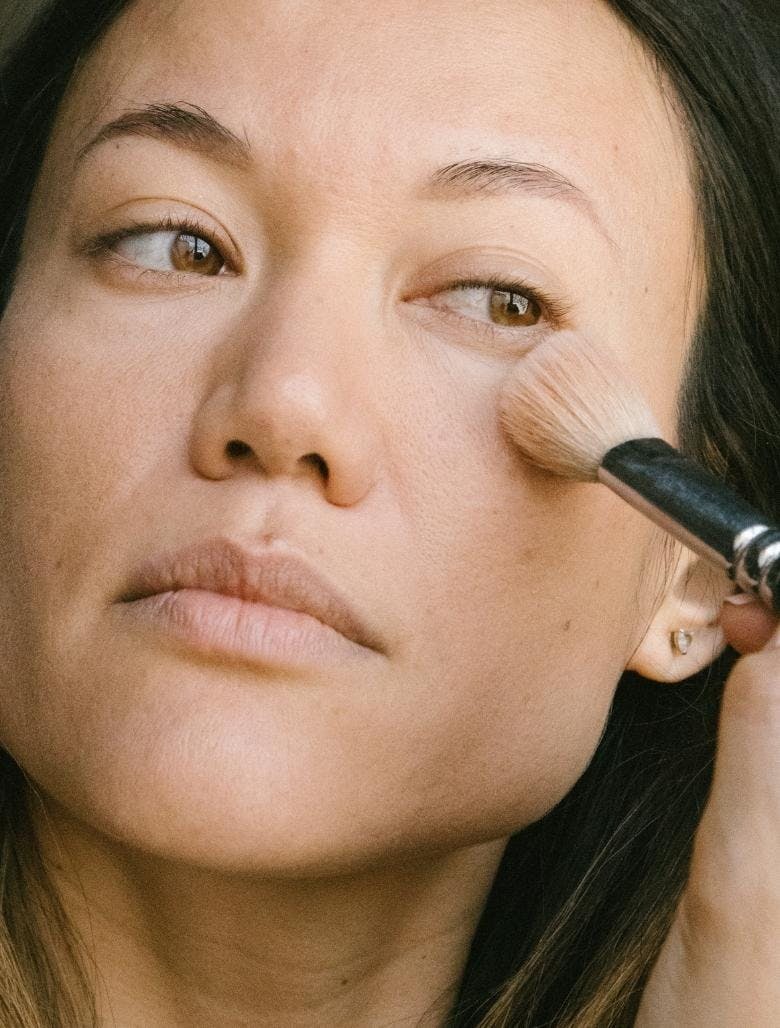woman applying foundation with brush