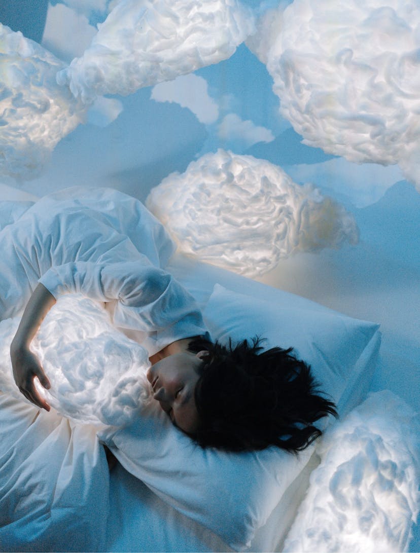 woman sleeping surrounded by clouds