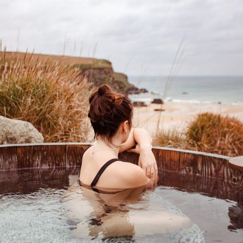 woman in hot tub overlooking the beach